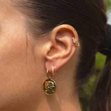 Boucles d'Oreilles Alya - mini créoles dorées pendentif rond texturé étoile en relief portées à l'oreille - LELIEGE