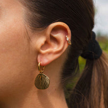 Boucles d'Oreilles Bagatelle - mini créoles dorées pendentif floral gravé portées à l'oreille - LELIEGE