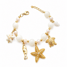 Bracelet Aphros - perles blanches rondes et facettées intercalaires dorées 5 charms marins sur fond blanc - LELIEGE
