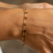 Bracelet Cozumel - chaîne fine dorée 18k 8 pendentifs soleil ajourés porté au poignet - LELIEGE