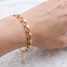Bracelet Lerma - bracelet à maille graphique dorée et perles d’onyx rouge porté au poignet - LELIEGE