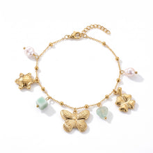 Bracelet Monarque - bracelet doré à charms et perles nacrées sur fond blanc - LELIEGE