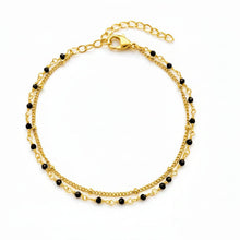 Bracelet Notte - bracelet doré à double rang, perles de spinelle noir et chaîne perlée sur fond blanc - LELIEGE